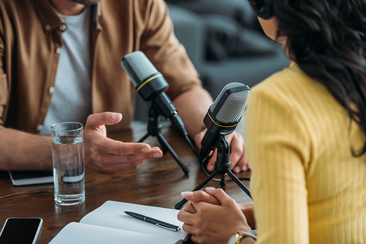 Cropped view of two radio hosts recording a podcast in studio