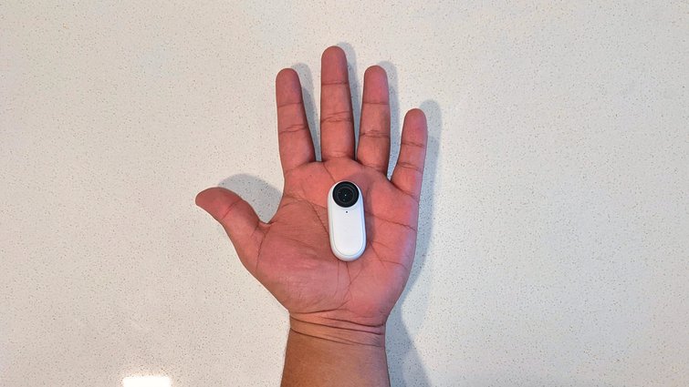 A man's hand displays the Insta 360 Go 2