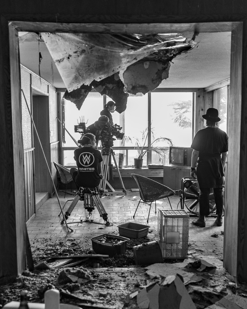 Camera crew setting up a scene in a rustic, indoor location