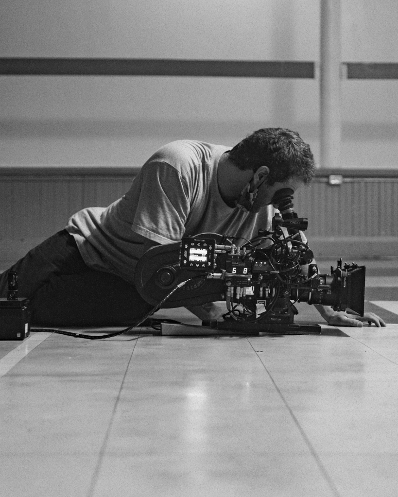 A cameraman on the floor shooting a scene for a short film