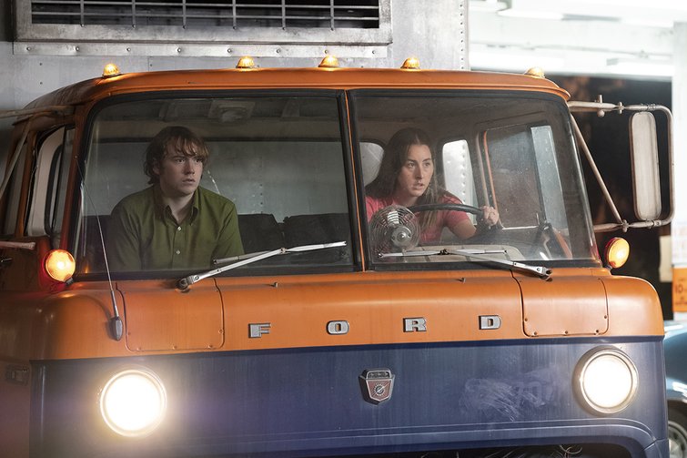 Actors driving an old van in the film Licorice Pizza