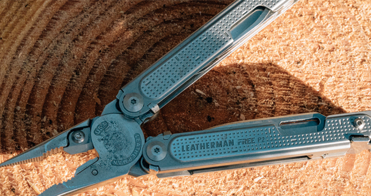 Closeup of a Silver-tone Leatherman Multitool on a Woodgrain Backdrop