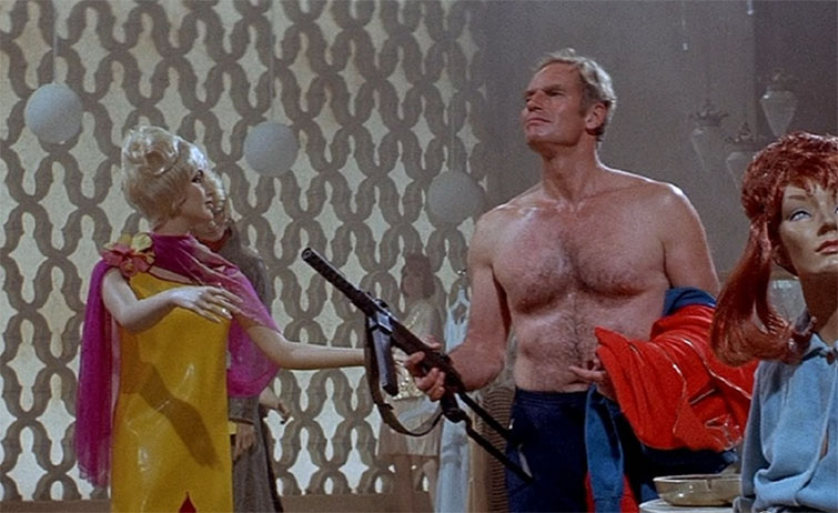Shirtless Charlton Heston carrying a gun in the movie The Omega Man