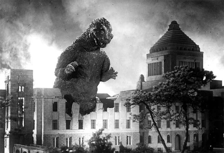 Scene from Godzilla showing the eventual anti-hero tearing down a city building
