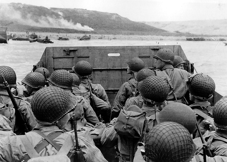 Black-and-white photo of American troops approaching Omaha Beach