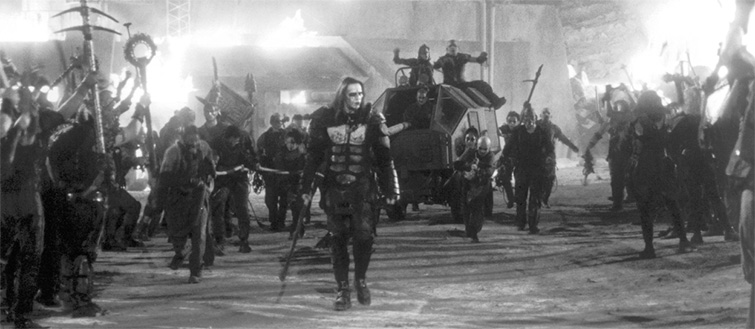 Frame from Ghosts of Mars showing an ensemble of characters marching against a blazing apocalyptic Mars backdrop