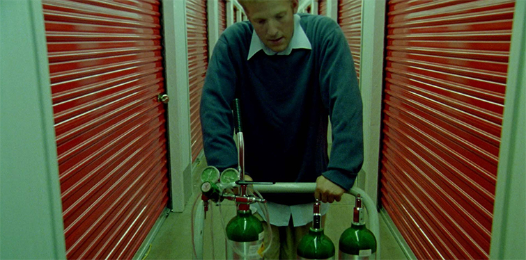 Screen grab from Primer showing the main character pushing a cart through a storage facility