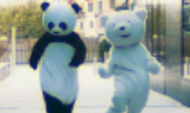 The Channel Blur effect added to a photo featuring two people in bear costumes walking down the street