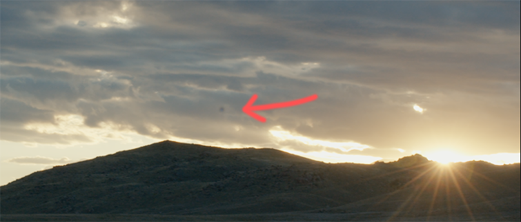 Arrow pointing to a dead pixel in a mountain sunset photo